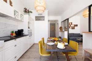 eine Küche und ein Esszimmer mit einem Tisch und gelben Stühlen in der Unterkunft La Colline YourHostHelper in Cannes