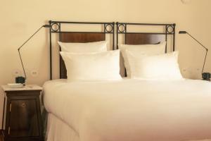 a bed with white pillows and a black frame at Hotel la Ponche in Saint-Tropez