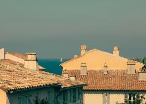 a view of roofs of buildings and the ocean at Hotel la Ponche in Saint-Tropez