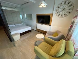 Cette chambre comprend un lit et une horloge murale. dans l'établissement Batumi Real Lux, à Batoumi