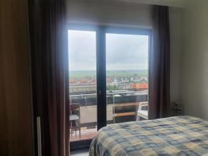 a bedroom with a view of a city from a window at Appartement met 2 slaapkamers op zeedijk Middelkerke in Middelkerke