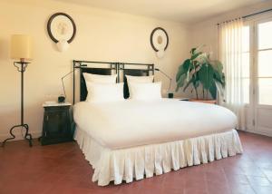 a bedroom with a large bed with white sheets and pillows at Hotel la Ponche in Saint-Tropez