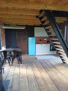 a kitchen with a table and a blue refrigerator at Między Olchami domek nad jeziorem. Noclegi całoroczne. Cisza, spokój. in Barczewo