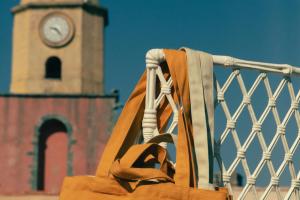 a brown bag with a clock tower in the background at Hotel la Ponche in Saint-Tropez
