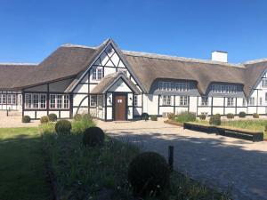 a large white building with a large roof at Hotel Nørrevang in Marielyst