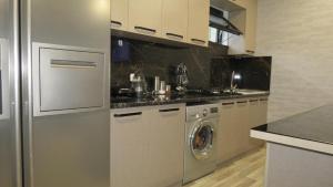una cucina con frigorifero e lavatrice di Bibo's Kokhi Guesthouse a Kazbegi