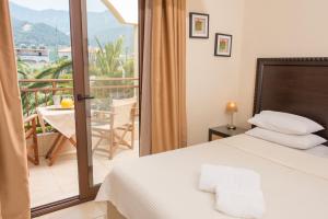 a bedroom with a bed and a balcony with a view at Villa Pipini Luxury Studios in Limenas