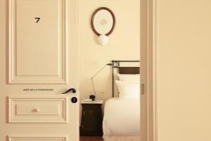a bedroom with a bed and a mirror on the wall at Hotel la Ponche in Saint-Tropez