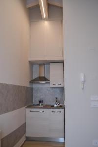 a kitchen with white cabinets and a sink at Garda Lake Maison d'Isabella in Lonato