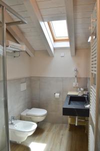a bathroom with a toilet and a sink and a skylight at Garda Lake Maison d'Isabella in Lonato