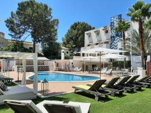 a swimming pool with lounge chairs and a building at La Concha Soul Boutique Hotel in Paguera