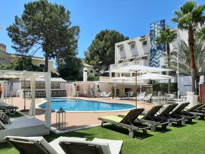 una piscina con sedie a sdraio e un edificio di La Concha Soul Boutique Hotel a Paguera