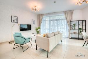 a living room with a couch and a chair at Airy 1BR at Park Island Sanibel Dubai Marina by Deluxe Holiday Homes in Dubai