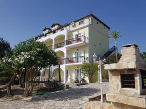 a white building with a tree in front of it at Seaview Apartments Tsilivi in Tsilivi