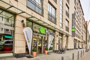 uma loja na frente de um edifício com grandes janelas em H+ Hotel Berlin Mitte em Berlim