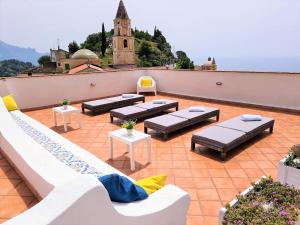 un patio avec des canapés et des tables sur le toit dans l'établissement La Casa Dei Venti, à Amalfi