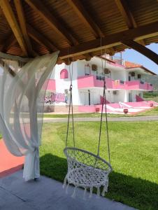 a swing on a patio with a house at Vigla House in Sykia Chalkidikis