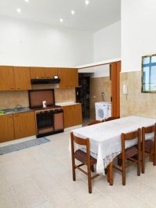 kuchnia ze stołem i krzesłami w pokoju w obiekcie Nonno Ciccio Apartment w mieście Lizzano