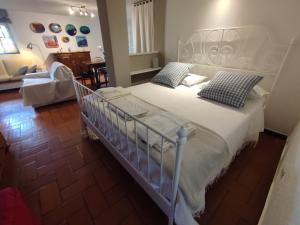 a bedroom with a large white bed with blue pillows at Independent apartment with a fabulous patio - Casa Penny in Cisano sul Neva