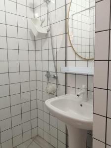 ein weißes Badezimmer mit einem Waschbecken und einem Spiegel in der Unterkunft Dream Days Guesthouse in Faro