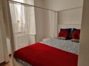 a bedroom with a red bed and a window at Dream Days Guesthouse in Faro