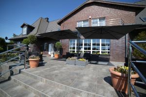 a patio with umbrellas in front of a house at Rezydencja Legrams in Darłowo