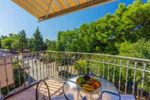 a table with a bowl of fruit on a balcony at Amfora Apartments in Crikvenica