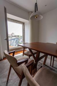 una sala da pranzo con tavolo, sedie e finestra di Stay In Apartments - D. Hugo 23 a Porto