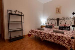 ein Schlafzimmer mit einem Bett mit einer Bettdecke und einem Regal in der Unterkunft Casa De Nohales in Nohales