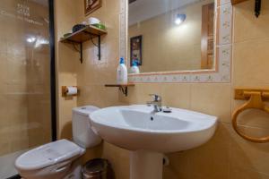 ein Badezimmer mit Waschbecken, Toilette und Spiegel in der Unterkunft Casa De Nohales in Nohales