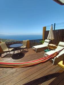 una terraza con sillas, una mesa y una sombrilla en Apartamento Mencey de StarApsTenerife, en Sauzal
