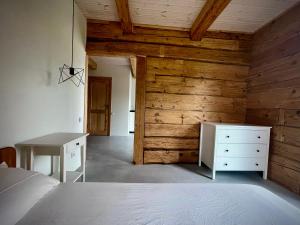 a bedroom with a bed and a wooden wall at Plateliai Samogitia Barn in Plateliai
