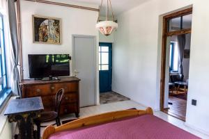a bedroom with a tv on a wooden dresser at Liget Vendégház in Révfülöp