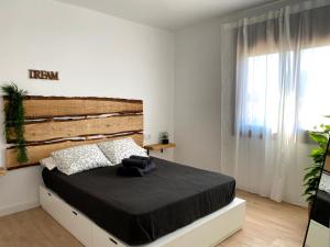 a bedroom with a large bed with a wooden headboard at Secona DOMUS NATURALIS in Torredembarra