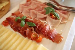 a plate of meats and cheese on a table at Hotel Murter in Murter