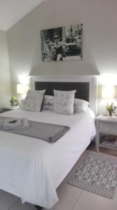 a bedroom with a large white bed with two lamps at Two Vines Romantic Guest Studio in Stellenbosch