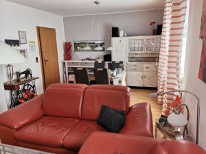 a living room with a brown leather couch at Ferienwohnungen Am Bruttiger Moselsteig in Bruttig-Fankel
