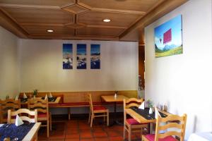 a dining room with tables and chairs in a restaurant at Hotel Sonnwendhof Engelberg in Engelberg +37 photos