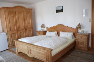 um quarto com uma cama grande e mobiliário em madeira em Brombergerhof Münsing em Münsing