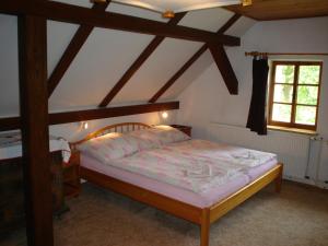 a bedroom with a wooden bed and a window at Ubytování v Českém ráji in Holín