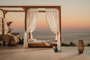a hotel room with a bed and a canopy at Emerald Villas in Agios Nikolaos