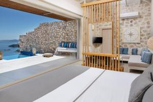 a bedroom with a view of the ocean at Emerald Villas & Suites - The Finest Hotels Of The World in Agios Nikolaos