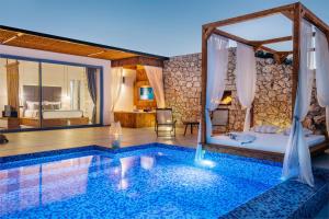 a hotel room with a pool and a bed and a bedroom at Emerald Villas & Suites - The Finest Hotels Of The World in Agios Nikolaos