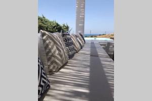 eine Reihe von Kissen auf einem Bürgersteig in der Unterkunft Luxury Cycladic Villa with Seaview and MiniPool in Naxos Chora