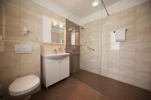 a bathroom with a toilet and a sink and a shower at Hotel Murter in Murter +122 photos