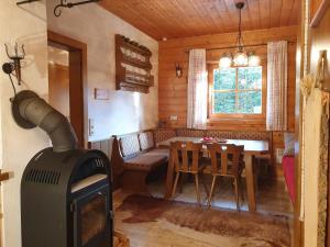 salon z kominkiem i stołem w kabinie w obiekcie Alm-Ferienhaus Gaisegg am Klippitztörl w mieście Bad Sankt Leonhard im Lavanttal