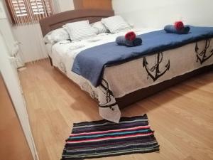 ein Schlafzimmer mit einem Bett mit einer blauen Decke und einem Teppich in der Unterkunft ANCHOR BAŠKA in Baška