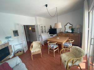 een woonkamer met een houten tafel en stoelen bij DOFI 1 in Tamariu
