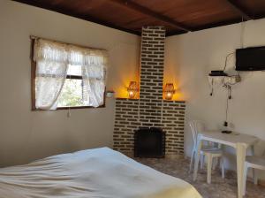 ein Schlafzimmer mit einem Bett und einem Tisch und einem Fenster in der Unterkunft Chalés & Casas Shallon Adonai in Visconde De Maua + 48 Fotos