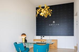 a dining room with a table and blue chairs at Abelia Sea Suites in Cefalù